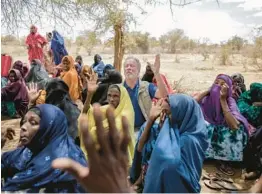  ?? BRIAN INGANGA/AP ?? World Food Program chief David Beasley meets with villagers Friday in northern Kenya. The U.S. will buy about 165,000 tons of grain from Ukraine for an aid shipment.