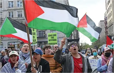  ?? ?? Hateful: Protesters at Columbia wave Palestinia­n flags and placards supporting intifada