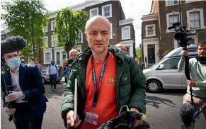  ??  ?? A protester writes a message outside the north London home of Britain’s Prime Minister Boris Johnson’s senior aids Dominic Cummings, pictured right, in London.