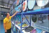  ?? YANG JUN / CHINA DAILY ?? A consumer checks out a toilet seat at a Topseat showroom. The firm’s colorful products feature many designs.