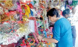  ??  ?? Shoppers select Christmas decoration­s in Pettah. Pix by Indika Handuwala and Athula Devapriya