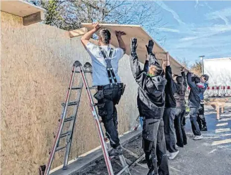  ?? FOTO: GEMEINDE ALTSHAUSEN ?? Mit vereinten Kräften errichten die Beteiligte­n eine neue Graffitiwa­nd.