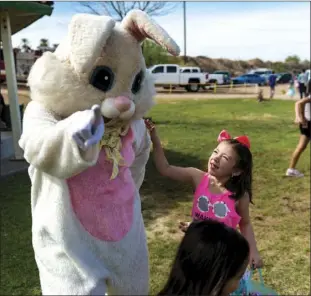  ?? VINCENT OSUNA PHOTO ?? A young girl greets the Easter Bunny during the annual Easter egg hunt event held at Pat Williams Park in Brawley on Saturday morning.