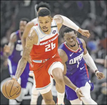  ?? Marcio Jose Sanchez The Associated Press ?? Sacramento Kings guard Kent Bazemore dribbles past Reggie Jackson of the Los Angeles Clippers during the first half of their game Saturday in Los Angeles.