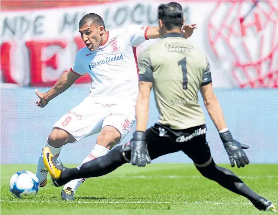  ?? JUANO TESONE ?? Implacable. Ramón Ábila abre el marcador con un derechazo ante Monetti. Huracán no tuvo oposición en el Lanús muletto.