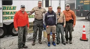  ?? PHOTOS COURTESY OF LOS ANGELES COUNTY SHERIFF’S DEPARTMENT VIA NYT ?? Rene Compean (center) is flanked by rescuers who were led to where he was stranded in rugged terrain after losing his way while hiking about 50 miles northeast of Los Angeles. He was located by a stranger with an unusual hobby, using a fuzzy photo.