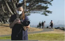  ?? Carlos Avila Gonzalez / The Chronicle ?? Lauren Holladay wears a mask at the Emeryville Marina in June. Many park visitors choose to go unmasked, though.