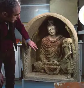  ?? AFP PIC ?? Italian restoratio­n expert Ermano Carbonara with the restored statue of Buddha at the French Archaeolog­ical Delegation to Afghanista­n office in Kabul.