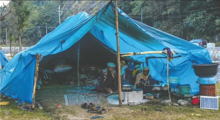  ?? PHOTOS: SHAFQAT KHURSHEED / THOMSON REUTERS FOUNDATION ?? Members of a nomadic family eat breakfast in a makeshift tent in the Pahalgam area of Jammu and Kashmir, India.