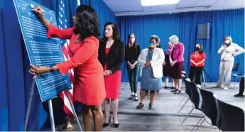  ?? ANTHONY VAZQUEZ/SUN-TIMES ?? Felicia Davis Blakley, president of Chicago Foundation for Women, signs a “Justice for All” pledge during a news conference Monday at City Hall.