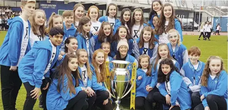  ??  ?? Steppin Out pupils pose next to the Aviva Premiershi­p Rugby trophy at the London Stadium last month