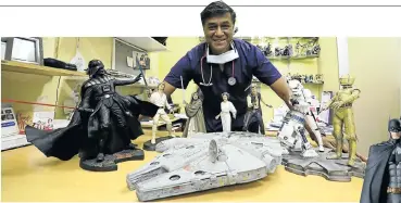  ?? Picture: Sandile Ndlovu ?? Durban doctor Mags Moodley in his consulting room, where he displays some of his collection of about 1,200 action figures. Batman, right, is his favourite superhero.