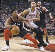  ?? Chris Young / Associated Press ?? Raptors guard Kyle Lowry (left) scored nine of his 24 points in the fourth to help beat the Spurs.