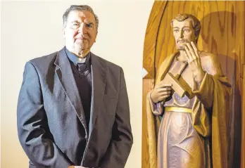  ?? PHOTOS BY APRIL GAMIZ/THE MORNING CALL ?? Monsignor Robert Wargo, of St. Joseph the Worker Church in Orefield, stands next to a statue depicting St. Joseph.