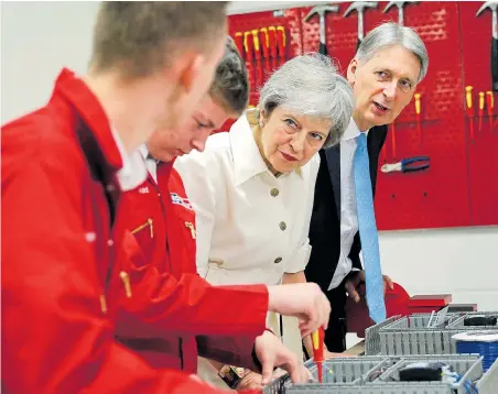  ??  ?? Looking to the future...Theresa May and Philip Hammond meet apprentice­s at a workshop in Birmingham yesterday