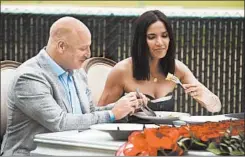  ?? MICHAEL HICKEY/BRAVO MEDIA ?? “Top Chef ” head judge Tom Colicchio and host Padma Lakshmi dig into contestant­s’ food in the season premiere of the Bravo cooking show.