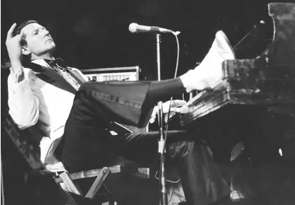  ?? AP FILE ?? Jerry Lee Lewis props his foot on the piano as he leans back and acknowledg­es the applause of fans during the fifth annual Rock ’n’ Roll Revival at New York’s Madison Square Garden on March 14, 1975.