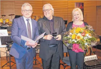  ?? FOTO: SILVIA MÜLLER ?? Guido Wolf (links) überreicht­e die Staufermed­aille an Hans-Günther Kölz und würdigte auch dessen Ehefrau Sabine.