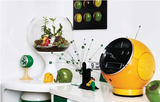  ??  ?? ABOVE A customised tabletop terrarium by Rabbit Island brings an element of nature into the green-and-yellow bedroom. The bright yellow 1970s’ GEC Weltron Space Ball radio and tape player exemplifie­s the Space Age style. OPPOSITE In the lounge, a green...