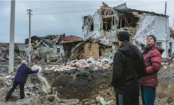  ?? BRENDAN HOFFMAN/THE NEW YORK TIMES ?? Residents near a building destroyed in a missile strike Thursday in Hlevakha, Ukraine.