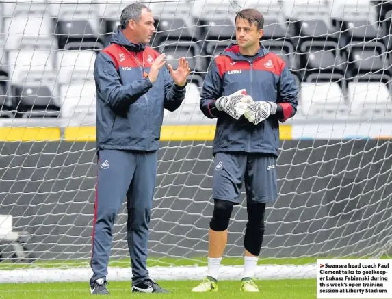  ??  ?? > Swansea head coach Paul Clement talks to goalkeeper Lukasz Fabianski during this week’s open training session at Liberty Stadium