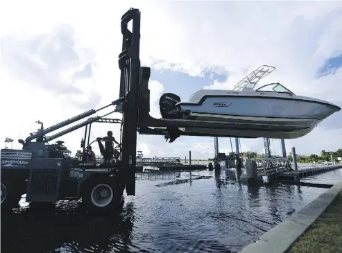  ?? MATT BORN / THE STAR-NEWS VIA AP ?? Daniel Elkins lifts a boat out of the water in preparatio­n for Hurricane Florence at Wrightsvil­le Beach, N.C., Tuesday. Catastroph­ic flooding and destructiv­e winds are becoming likely in the eastern Carolinas north of Charleston, S.C.