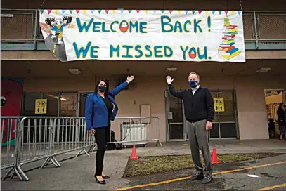  ?? JAE C. HONG / AP ?? Los Angeles Unified School District Superinten­dent Austin Beutner, right, and Gabriela Rodriguez, principal of Heliotrope Avenue Elementary School, pose for photos on the first day of in-person learning in Maywood on Tuesday. More than a year after the pandemic forced all of California’s schools to close classroom doors, some of the state’s largest school districts are slowly beginning to reopen this week for in-person instructio­n.