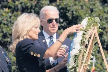  ?? MANUEL BALCE CENETA/AP ?? President Joe Biden observes as first lady Jill Biden touches the flowers on a wreath during a ceremony honoring fallen law enforcemen­t officers Saturday at the U.S. Capitol. Biden spoke at the 40th Annual National Peace Officers’ Memorial Service to remember the 491 law enforcemen­t officers who died in the line of duty in 2019 and 2020.