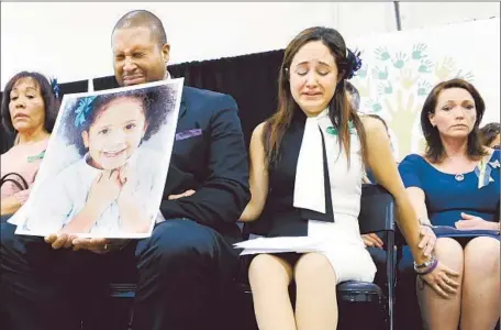  ?? Jessica Hill Associated Press ?? JIMMY GREENE holds a photo of daughter Ana Marquez-Greene, who was killed in the rampage at Sandy Hook Elementary School, as his wife, Nelba Marquez-Greene, center, comforts him and Nicole Hockley, right, mother of victim Dylan Hockley.