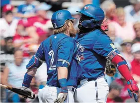  ?? CHARLIE NEIBERGALL THE ASSOCIATED PRESS FILE PHOTO ?? The Toronto Blue Jays’ Vladimir Guerrero Jr., right, reacts with teammate Justin Turner after hitting a home run in a spring training game against the Philadelph­ia Phillies in Dunedin, Fla., earlier this month.