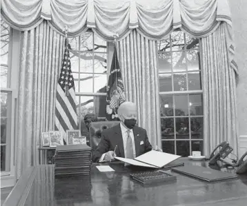  ?? EVAN VUCCI/AP ?? President Joe Biden signs a series of executive orders on Inaugurati­on Day at the White House in Washington.