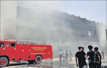  ?? SAMEER SEHGAL /HT ?? Fire operations underway at Guru Nanak Dev Hospital in Amritsar and (below) state power and PWD minister Harbhajan Singh ETO interactin­g with patients and their attendants who had been evacuated following the incident.