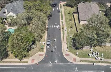  ?? Jay Janner Austin American-Statesman ?? BOMB INVESTIGAT­ORS work at the scene of an explosion in an Austin, Texas, neighborho­od on Monday. The blast, the fourth in a string of attacks this month in the city, wounded two men Sunday night.