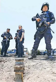  ??  ?? En el municipio de Quecholac, Puebla, policías resguardan ductos de Pemex de los que grupos de huachicole­ros extraen combustibl­e de forma ilegal.