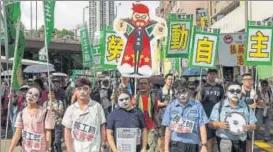  ?? AFP ?? People at protest march in Hong Kong on Saturday, coinciding with the 20th anniversar­y of the city's handover from British to Chinese rule.