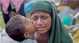  ?? AP ?? A Rohingya child places a kiss on his mother’s cheek near Teknaf area. —