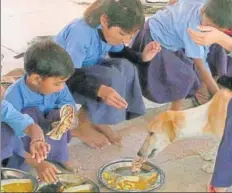  ??  ?? Stray dogs snatch food from the plates of students at the Khat Kalan Government Secondary School in Rajasthan.