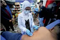  ?? Reuters ?? Hannaa Jassem, 24, an Iraqi nurse, helps a wounded man in Baghdad.—