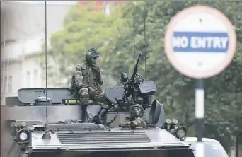  ?? Associated Press ?? Soldiers sit on a military vehicle parked on a street Thursday in Harare, Zimbabwe. People across the country endured another day of uncertaint­y amid quiet talks to resolve the country’s political turmoil.