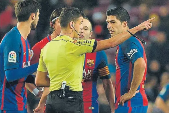  ?? LLUÍS GENÉ / AFP ?? Gil Manzano señala a Luis Suárez el camino de los vestuarios después de haberle mostrado una tarjeta roja, el pasado martes