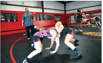  ?? PHOTOS BY STACI VANDAGRIFF/THREE RIVERS EDITION ?? Searcy head coach Jerry Evans, in the background, looks on as Maty Lincoln, left, and Trinity Danberry wrestle in the wrestling room on the high school campus.