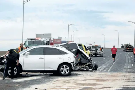  ?? ALLAN BENNER/POSTMEDIA NEWS ?? Emergency crews work to clear the wreckage after a multi-vehicle collision on the Garden City Skyway closed the QEW to traffic, on Thursday.