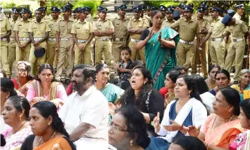  ??  ?? Indian police look on as Hindu activists protest in Maniyar in Kerala’s Pathanamth­itta district, following the arrest of 68 devotees at the flashpoint Sabarimala temple. — AFP photo