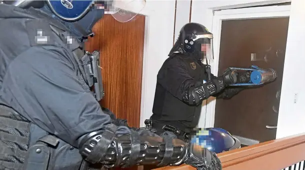  ?? ?? RAID: Officers force open a door in Powis Place, Aberdeen, during an anti-drugs operation on Wednesday. Picture by Chris Sumner