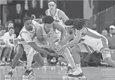  ?? ETHAN MILLER/GETTY IMAGES ?? Arizona State’s Desmond Cambridge Jr. tries to control the ball against Arizona’s Cedric Henderson Jr. and Kylan Boswell in the first half of a semifinal game of the Pac-12 basketball tournament at T-Mobile Arena.