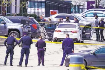  ?? MICHAEL CONROY AP ?? Law enforcemen­t officers examine the scene of Thursday night’s shooting at a FedEx ground facility near the Indianapol­is airport. The gunman, a former FedEx employee, killed eight people before shooting himself.