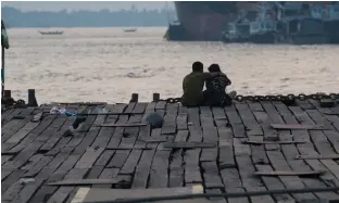  ?? — AP ?? A couple sitting at a jetty during sunset in Yangon. While contracept­ion is technicall­y available in Myanmar, few women know how to use it and many young people are too ashamed to buy it.