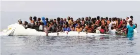  ?? — AFP ?? LIBYA: This file photo shows migrants waiting to be rescued from a sinking dinghy off the Libyan coastal town of Zawiyah, east of the capital, as they attempted to cross from the Mediterran­ean to Europe.