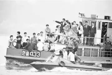  ??  ?? North Korean people take a tour on a vessel on the Yalu river outside Sinuiju, North Korea, opposite the Chinese border city of Dandong. — Reuters photo