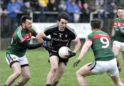  ??  ?? Darragh Cummins wins the ball despite the presence of two Mayo defenders in Ballina on Sunday. Pics: Tom Callanan.